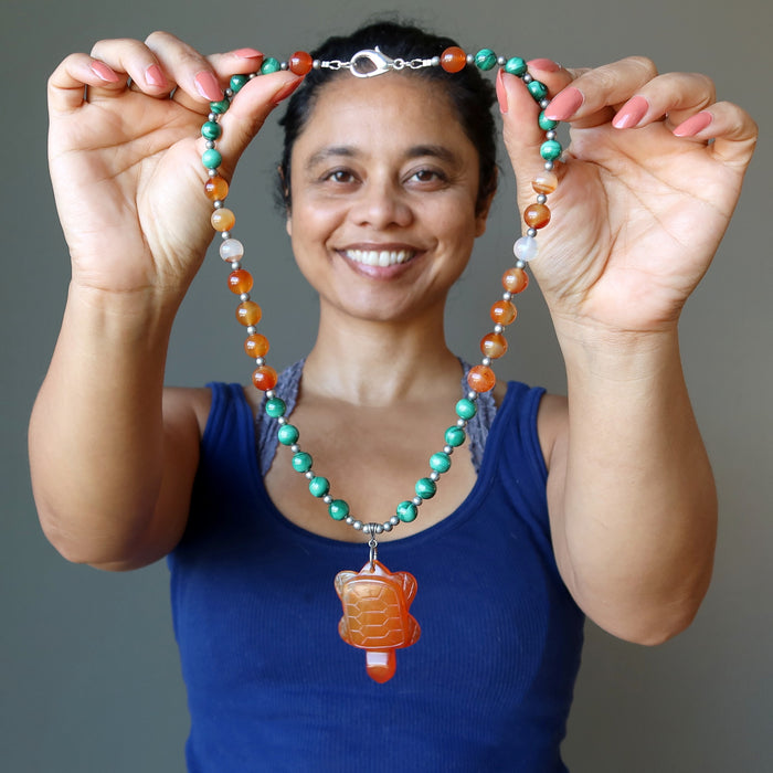 model holding carnelian turtle malachite necklace
