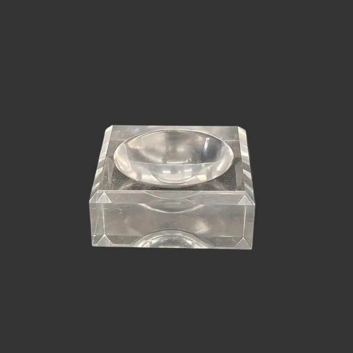 This acrylic stand is clear, glossy, and square in shape.