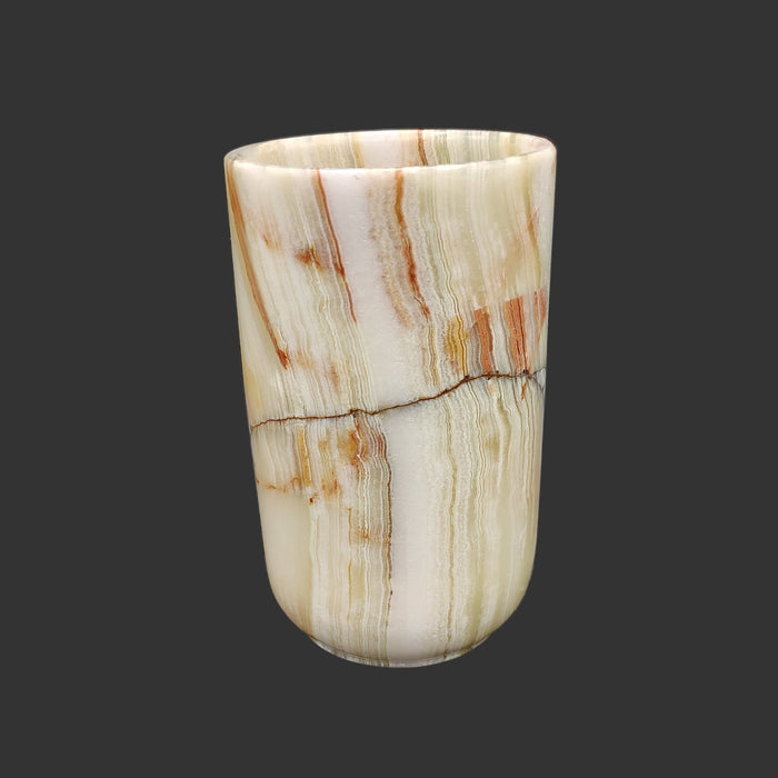 This front side of this onyx mug has a line of black in the middle with variations of orange and brown on top of the cream.
