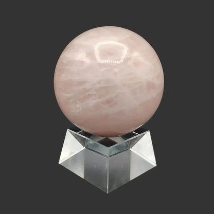 This is the left side oof this polished pink rose Quartz sphere on a clear and chunky square stand.