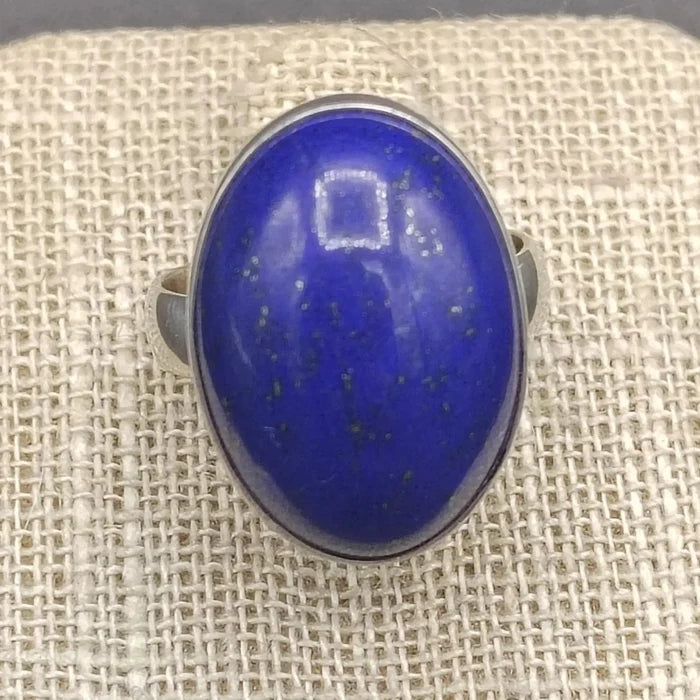 Close up of blue Lapis gemstone on a beige ring stand.