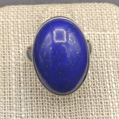 Close up of blue Lapis gemstone on a beige ring stand.