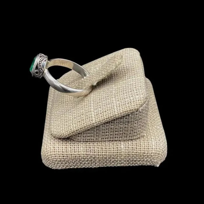 Side View Of Sterling Silver Oval Emerald Gemstone Ring, Band Is Polished Smooth Silver And The Setting Has A Paisley Design