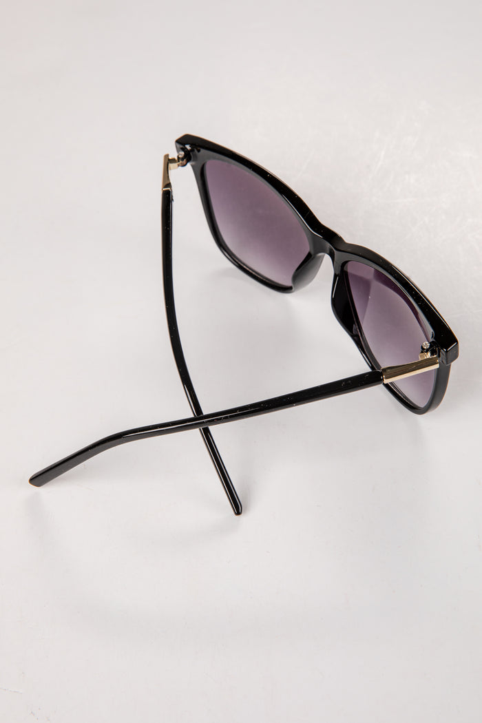 Black sunglasses with purple lenses on a white background