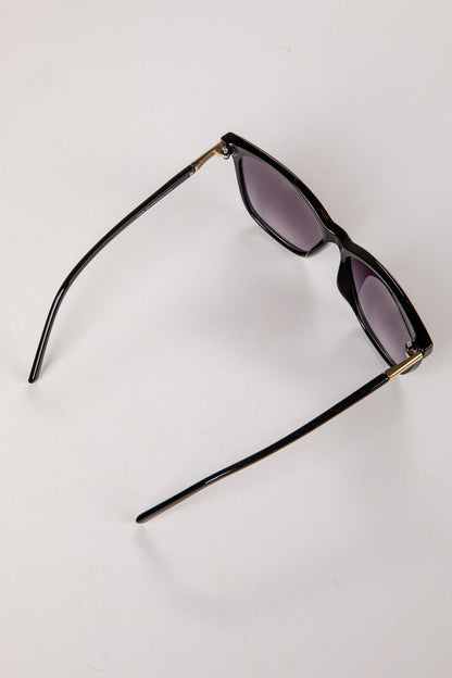 Black sunglasses with gold accents on a white background