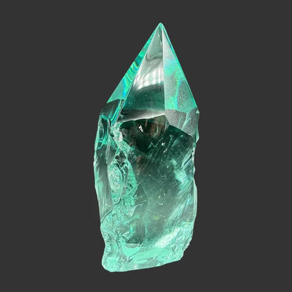 Front side of this blue green slag freeform, in front of a black background.